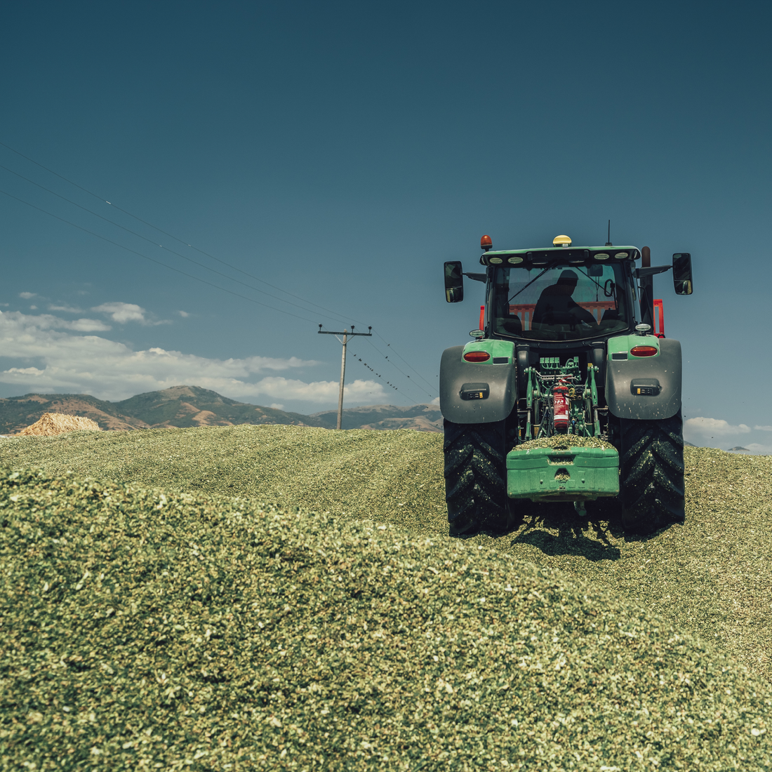 Tractor compacting silage on a farm, part of HITEC’s agricultural solutions
