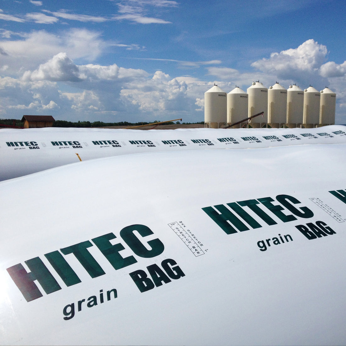 Large white grain bags by HITEC on a farm close up